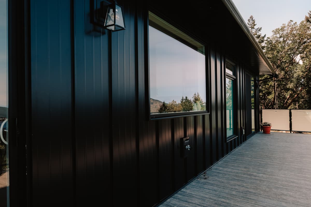 Black standing seam metal siding detail on covered deck